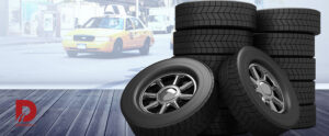 طراحی دیجیتالی از چند لاستیک که کنار هم قرار گرفته اند با لوگوی داداشی تایر در گوشه تصویر و یک تاکسی در بکگراند