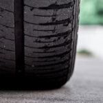 نمای نزدیک از لاستیک ماشین روی آسفالت