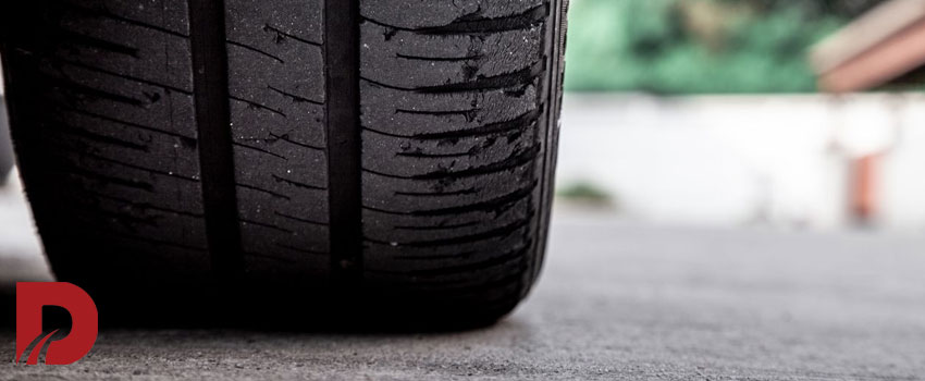 نمای نزدیک از لاستیک ماشین روی آسفالت