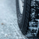 نمای نزدیک از لاستیک عقب یک ماشین در برف