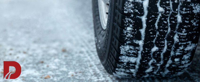 نمای نزدیک از لاستیک عقب یک ماشین در برف