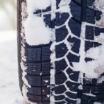 نمای نزدیک از لاستیک ماشین پوشیده شده با برف