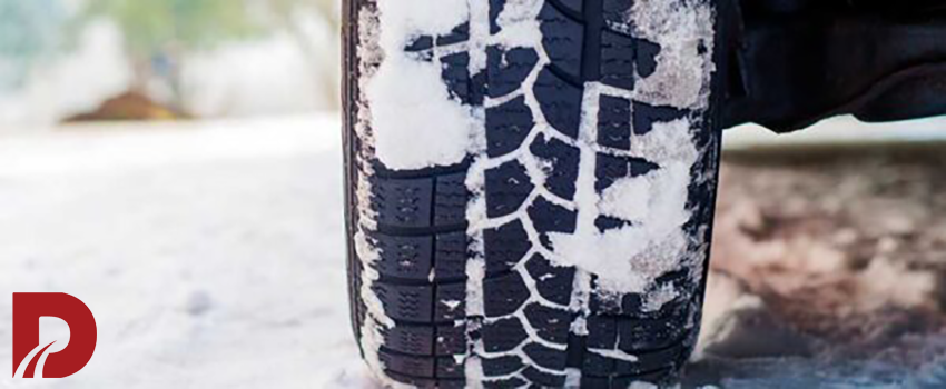 نمای نزدیک از لاستیک ماشین پوشیده شده با برف