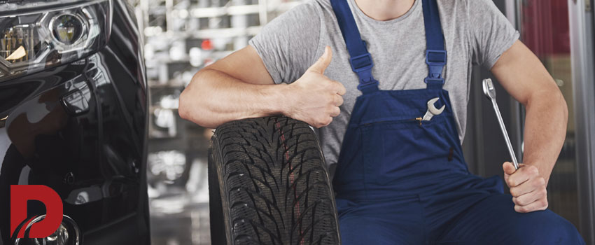 مکانیک تکیه داده به لاستیک و علامت اوکی را بادست نشان میدهد