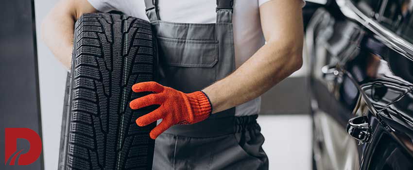 مکانیک در حال حمل یک لاستیک