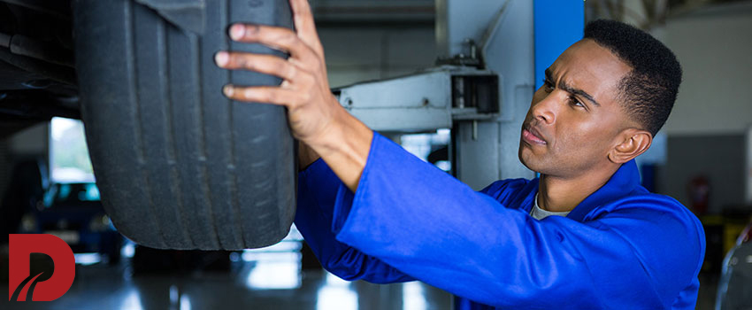 مکانیک درحال بررسی و تعمیر لاستیک ماشین