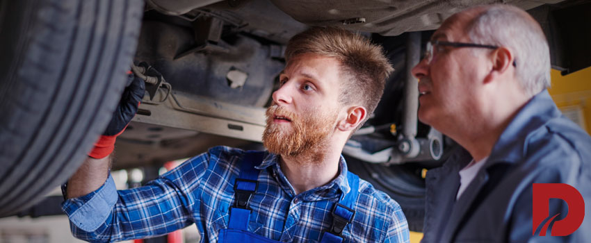 دو مکانیک در حال بررسی لاستیک ماشین