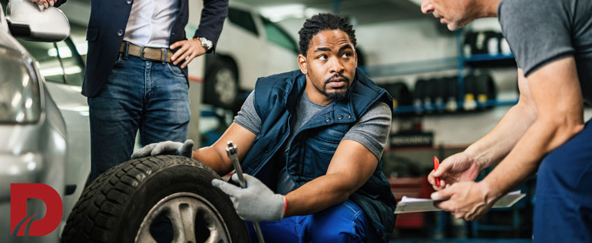 دو مکانیک در حال بررسی لاستیک ماشین